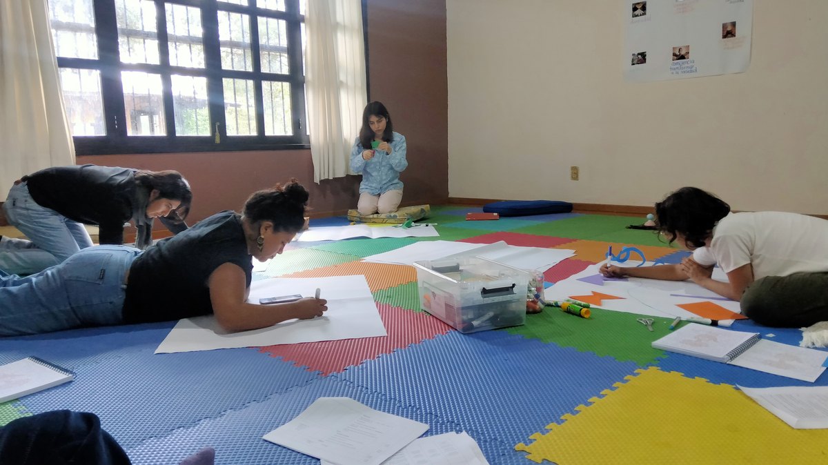 Participantes trabajando con papelógrafos en el piso